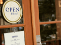 open and hours signage on shop front glass window